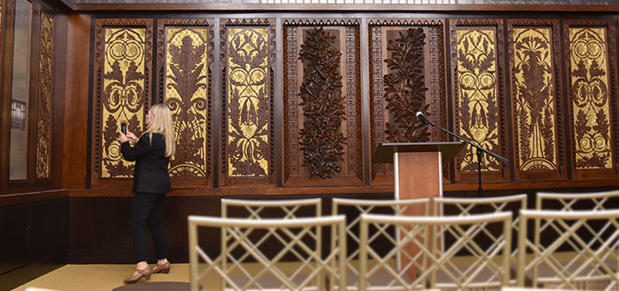 New SPMH Board Member Holly Brians Ragusa admires the display of the art-carved organ panels 