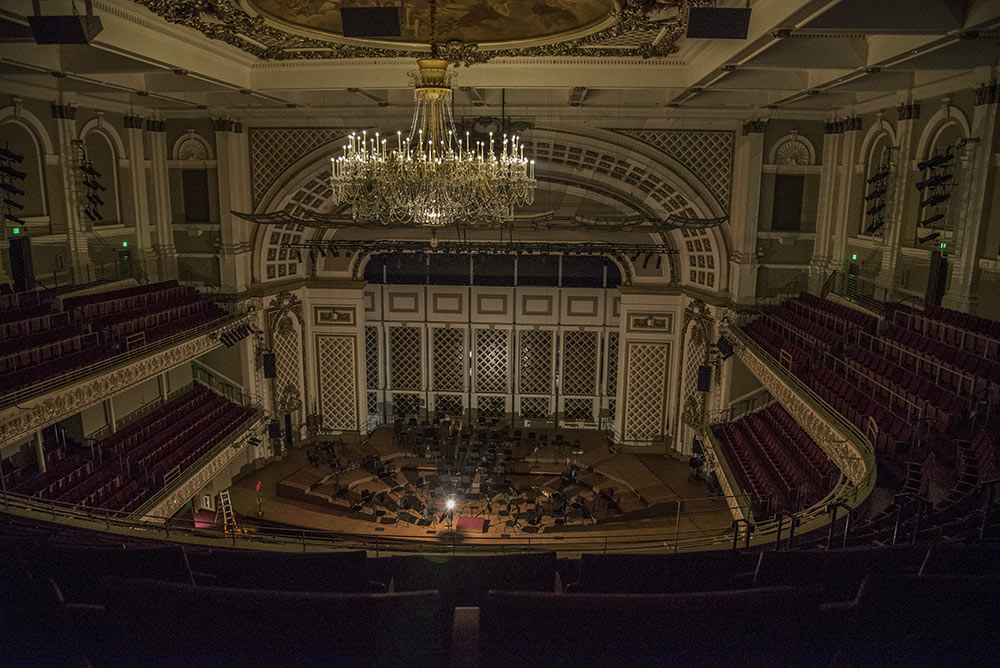 The auditorium is empty except for the ghost light on the stage