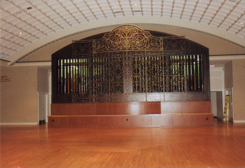 A view of the 30-foot wide by 18-foot deep organ chamber. There’s a grille in front of the open expression shades. A yellow 6-foot ladder gives perspective as to the size.