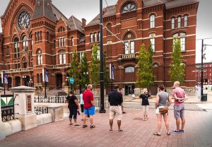 Guests wear masks and maintain distance during a Music Hall Outdoor Building Tour