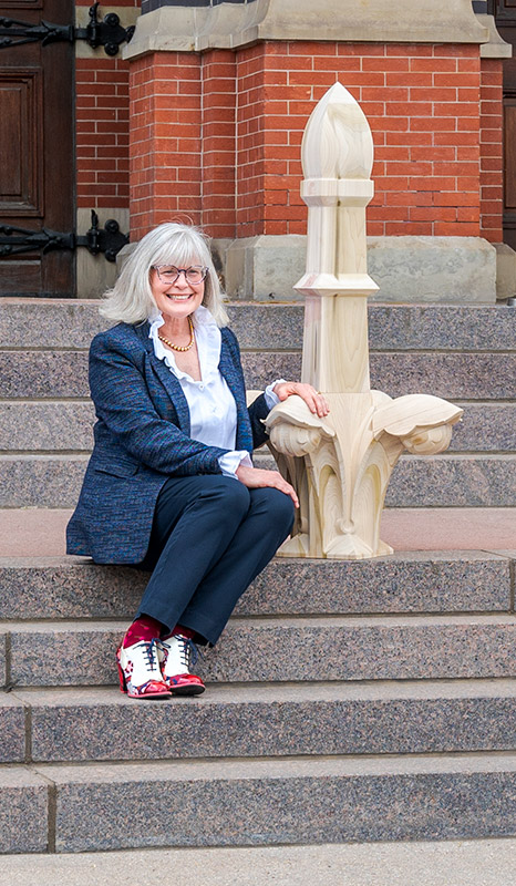 Historian/preservationist Thea Tjepkema on the steps of Cincinnati Music Hall with a model of a finial that is being restored.