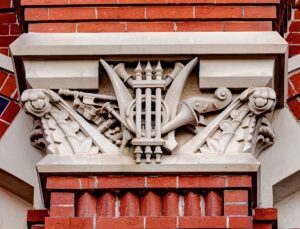 photo of a capital on Music Hall, carved with a lyre, horn, clarinet, violin scroll and bow