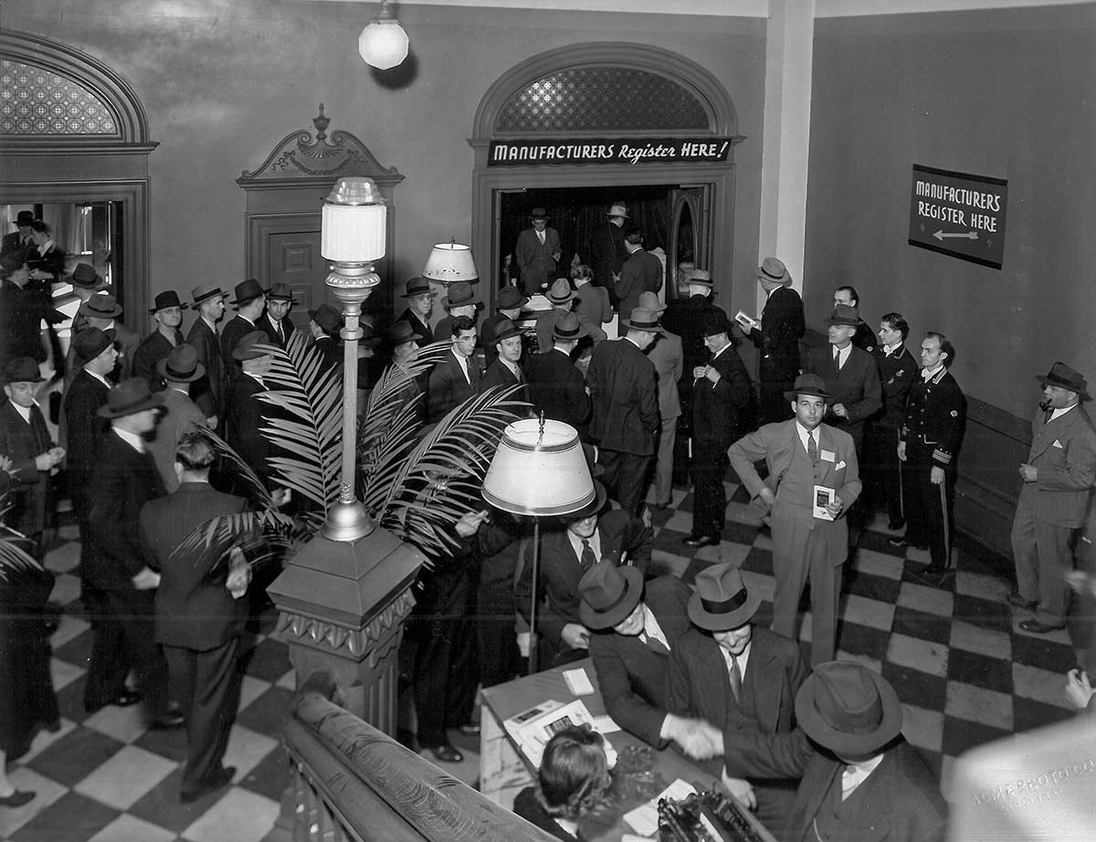 1928 photo of men in the north corridor lobby of Music Hall, at the foot of the grand staircase