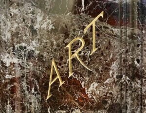 The word "ART" in gilt on one side of the pedestal of the statue of Reuben R. Springer in Cincinnati Music Hall.