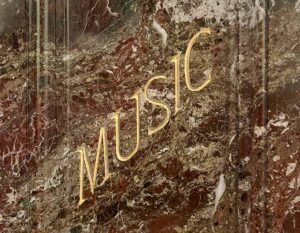 The word "MUSIC" in gilt on one side of the pedestal of the statue of Reuben R. Springer in Cincinnati Music Hall.